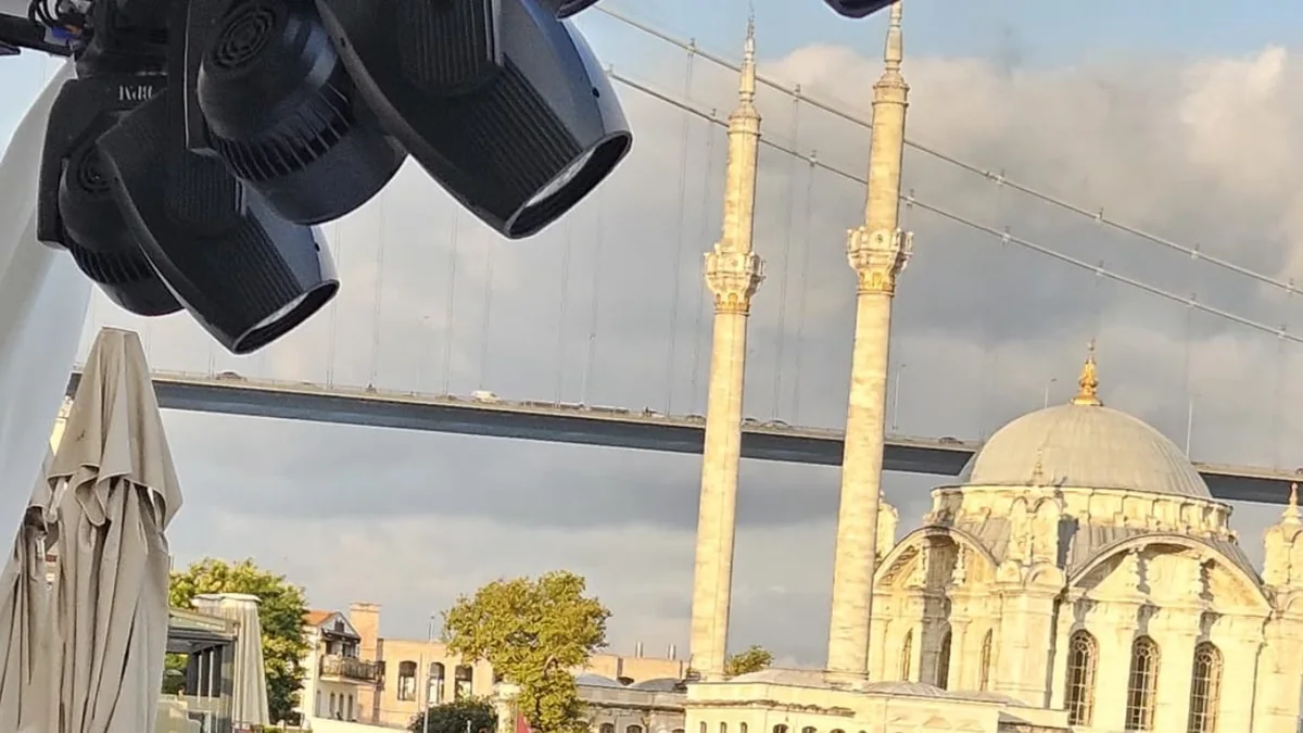 Boğaz manzaralı açık hava davetinde beyaz masa ve sandalye süsleme düzeni